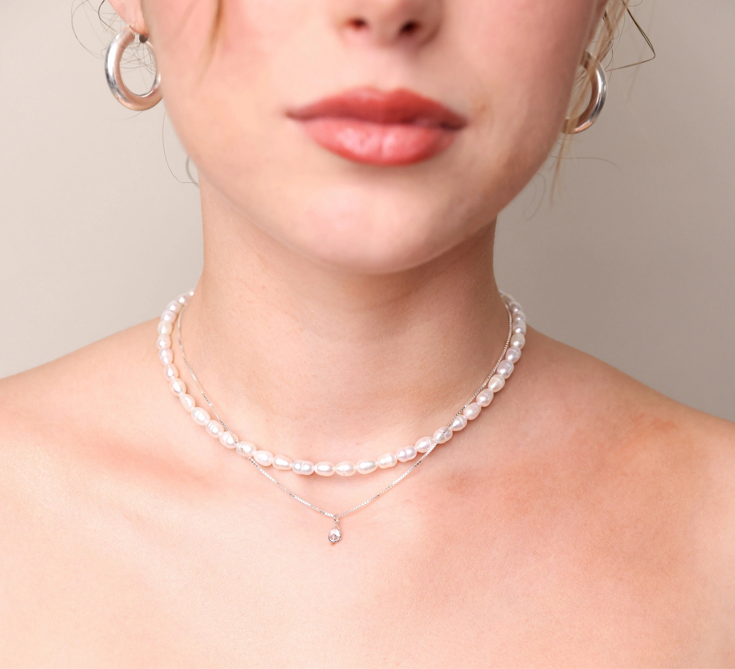 עגילי AMIT EARRINGS L כסף עבים על דוגמנית, תקריב על הפנים והצוואר המדגיש את החישוקים המבריקים.