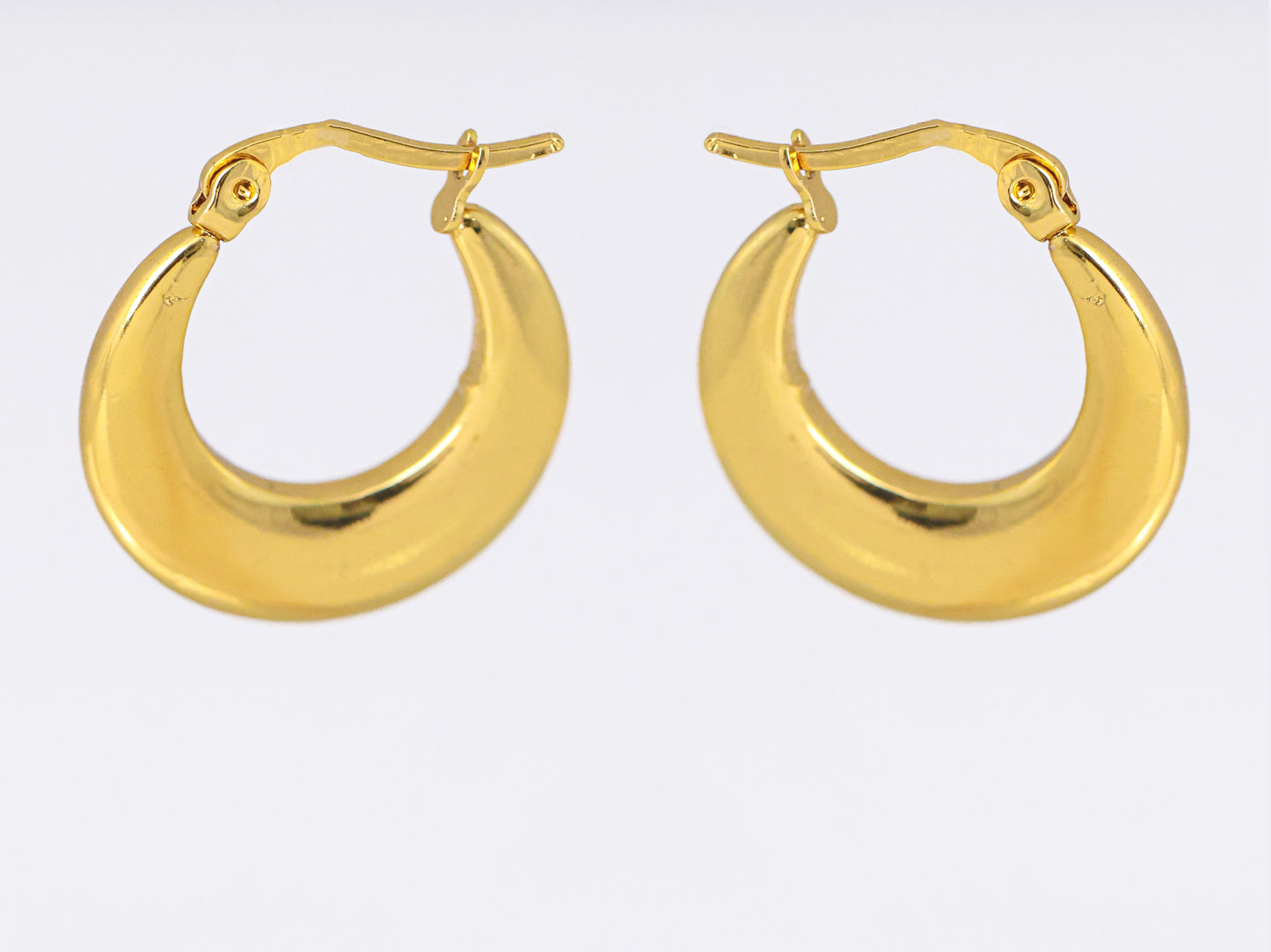 עגילי ÉLENA זהב של Lidi, חישוקים עבים מבריקים בצורת סהר, מבט חזיתי על מנגנון סגירה מפרקי.