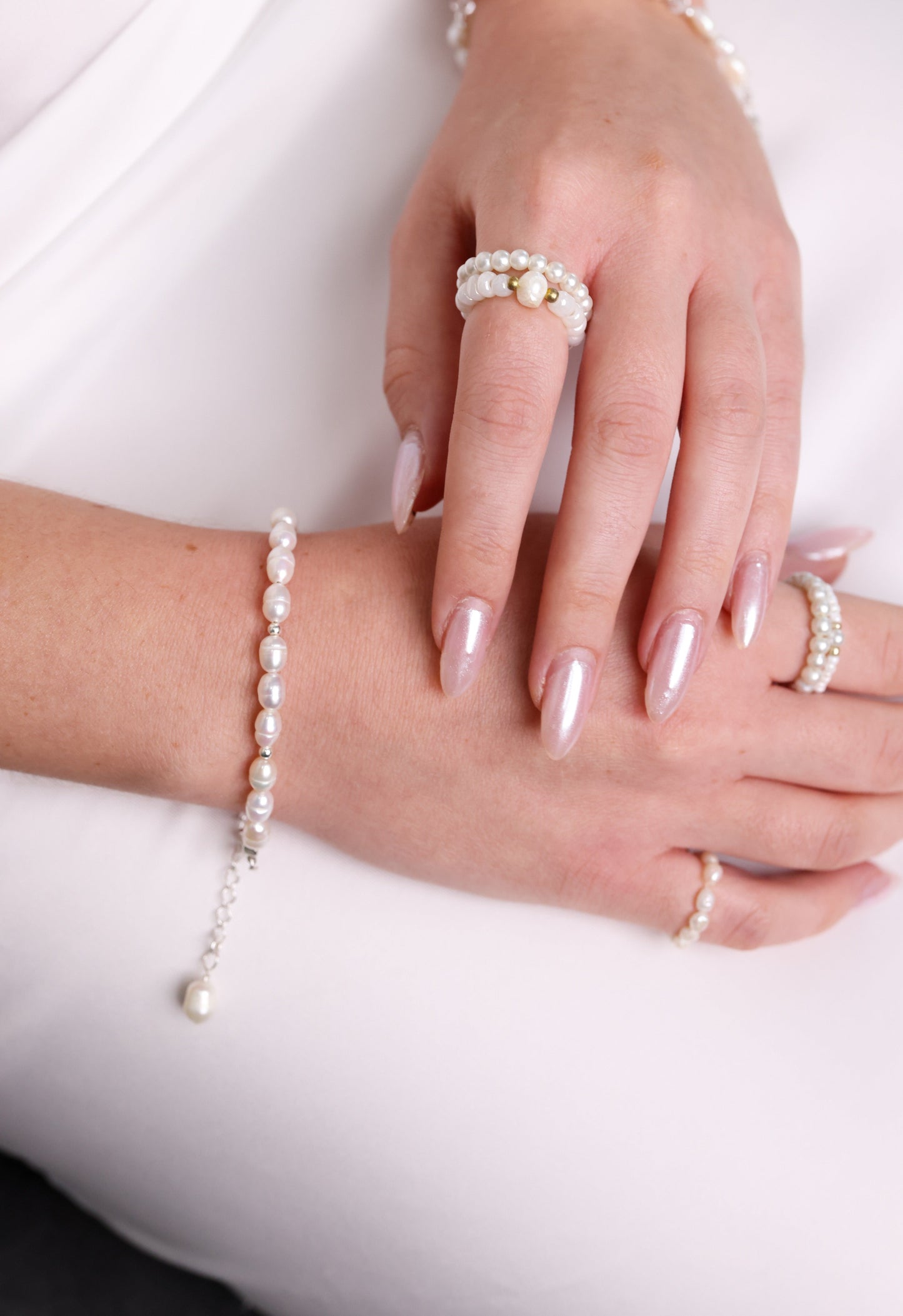 צמיד BELA BRACELET SILVER כסף ופנינים על פרק יד דוגמנית, מבט תקריב עם טבעות פנינים.