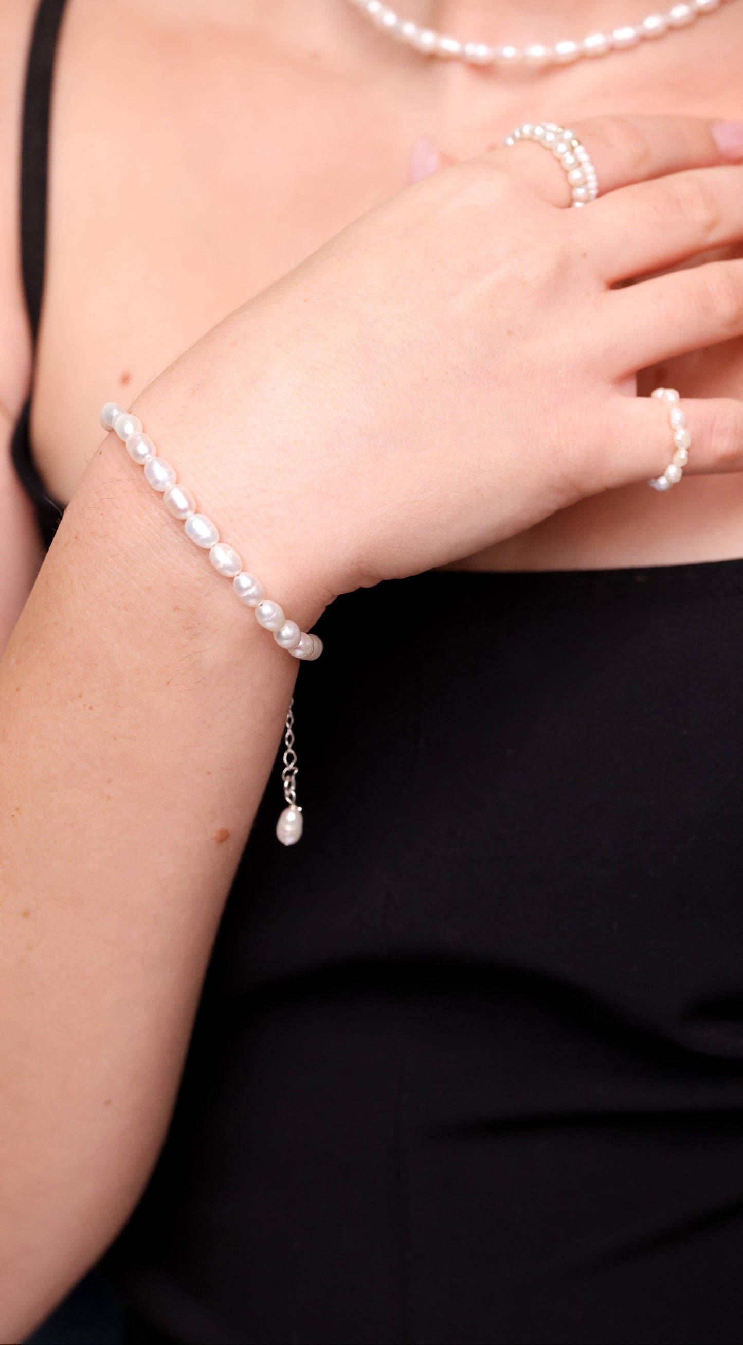 צמיד ANNA BRACELET SILVER עם פנינים טבעיות לא סדירות ותליון פנינה, על פרק יד דוגמנית, תקריב.