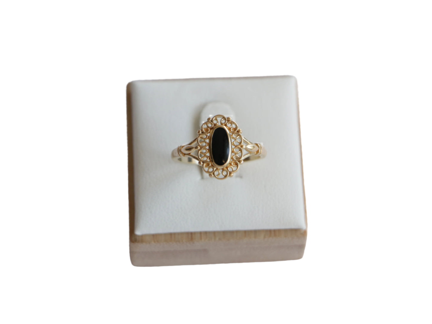 טבעת SOLE זהב עם אבן שחורה אובלית, מעוטרת במסגרת תחרה עדינה, מוצגת על סטנד לבן במבט קדמי.