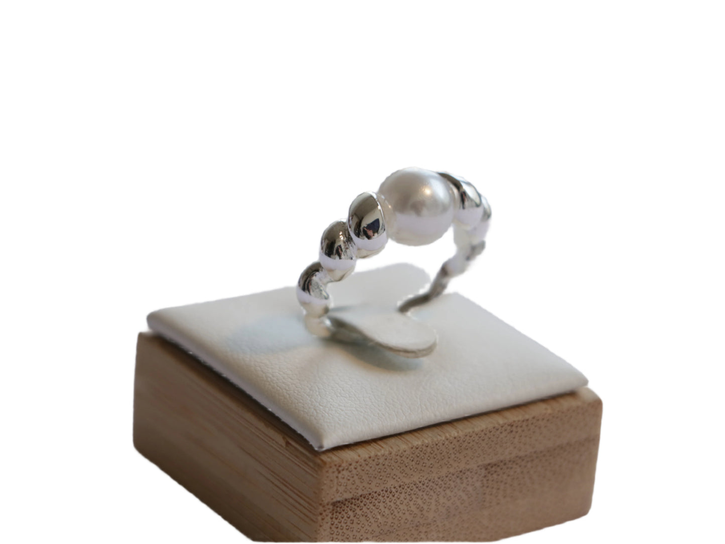 טבעת Lidi פנינה, פנינה מרכזית גדולה, מוקפת חרוזי כסף ופנינים קטנות. תקריב על מעמד עץ ולבן.