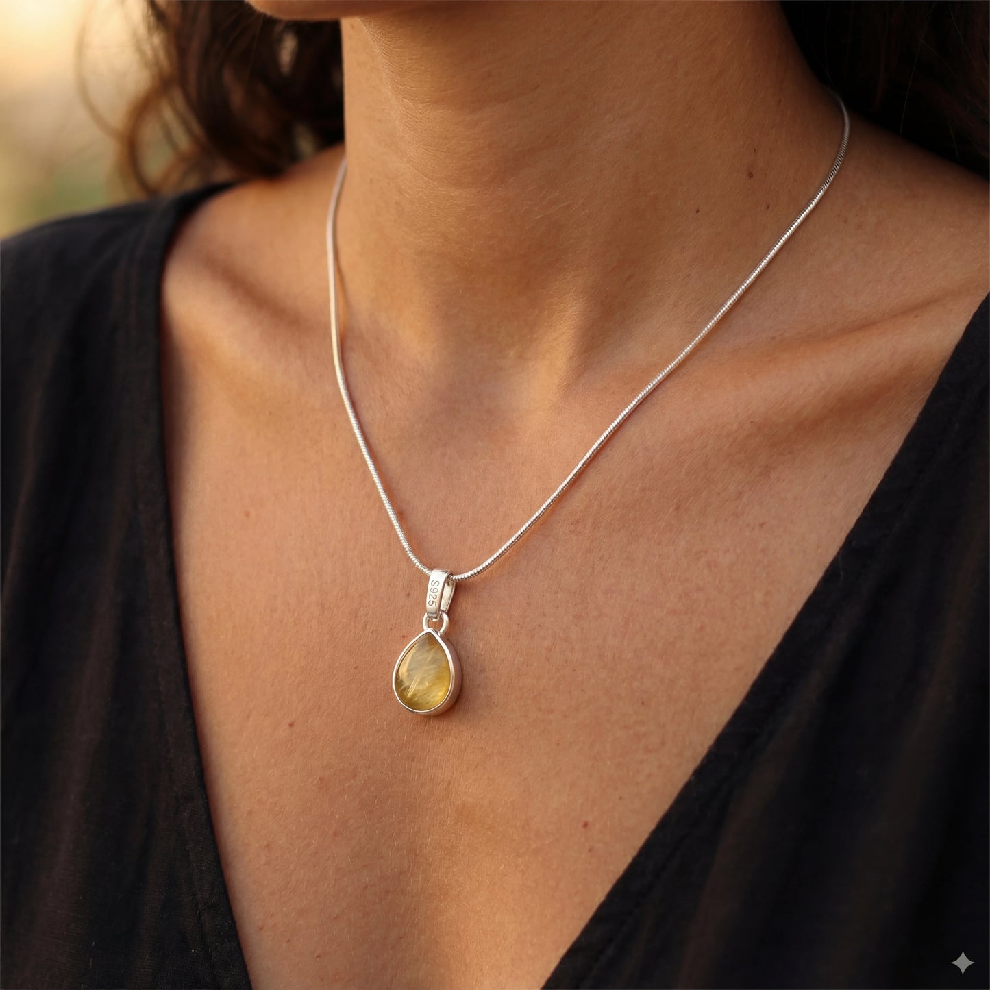 שרשרת NOY יוקרתית של Lidi מכסף 925 טהור עם תליון אבן פרידוט ירוקה וזוהרת על צוואר אישה.