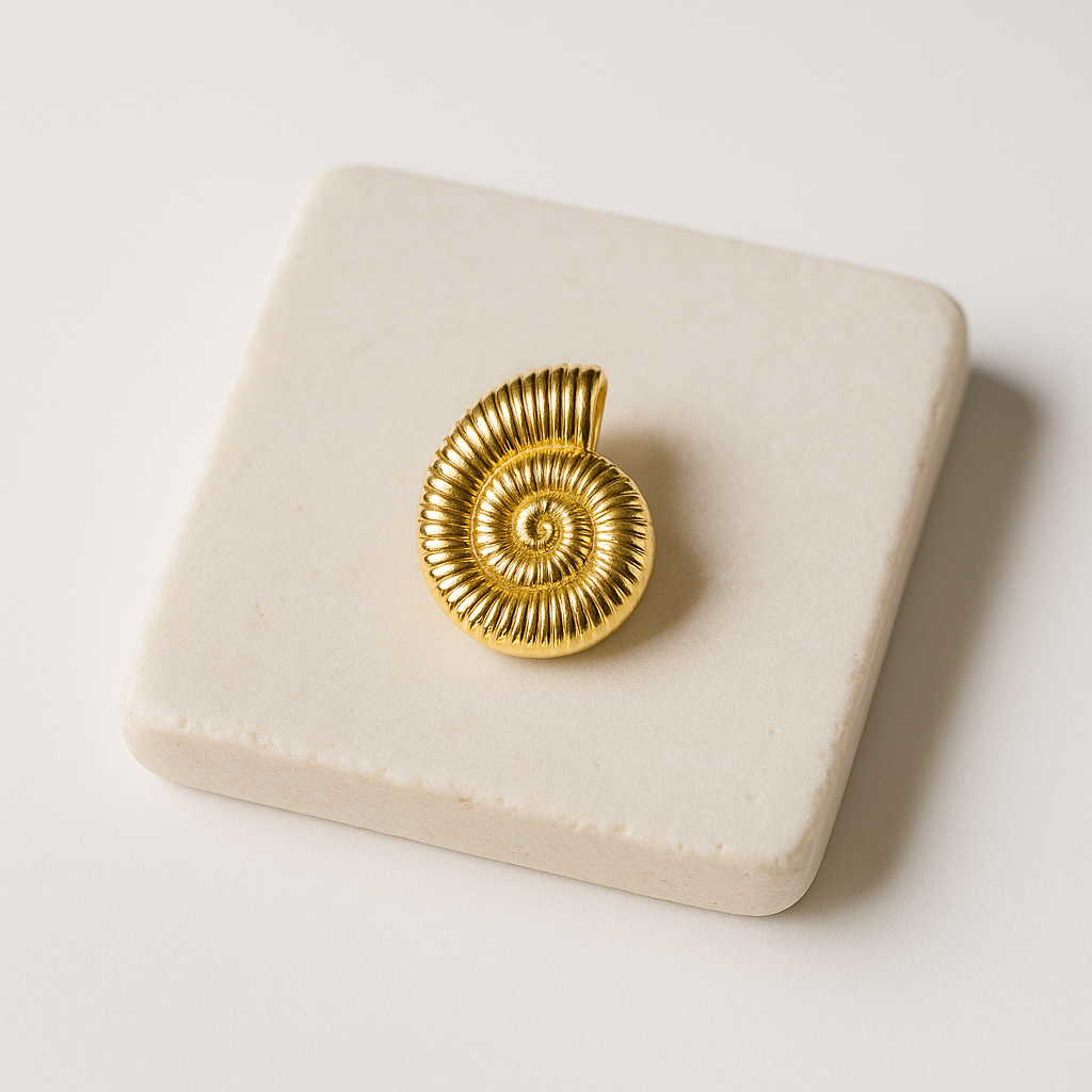 עגיל SHAB GOLD זהב בודד, עיצוב ספירלי מצולע דמוי צדף, מונח על לוח אבן בהיר, תקריב.