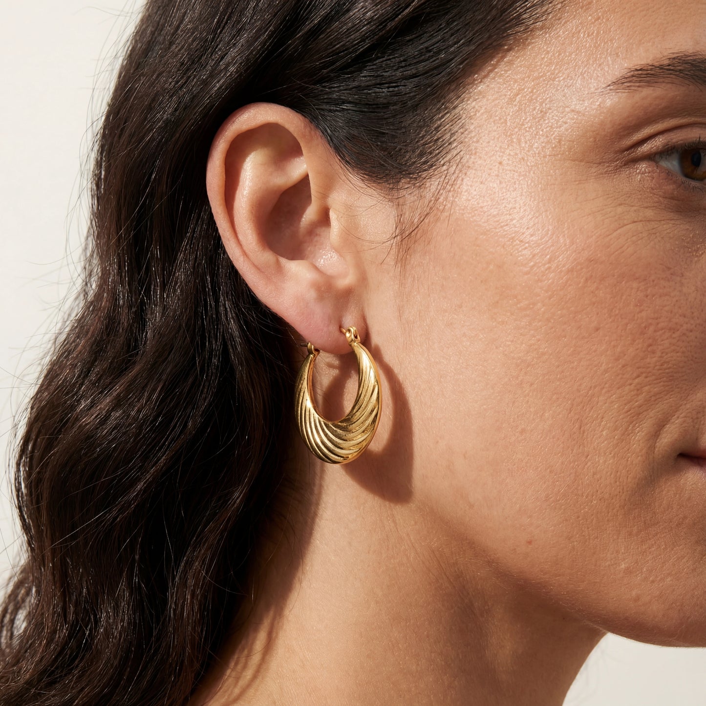 עגילי חישוק MIKA EARRINGS מזהב קלאסי של Lidi, בעיצוב נקי ואלגנטי, מונחים על רקע יוקרתי.