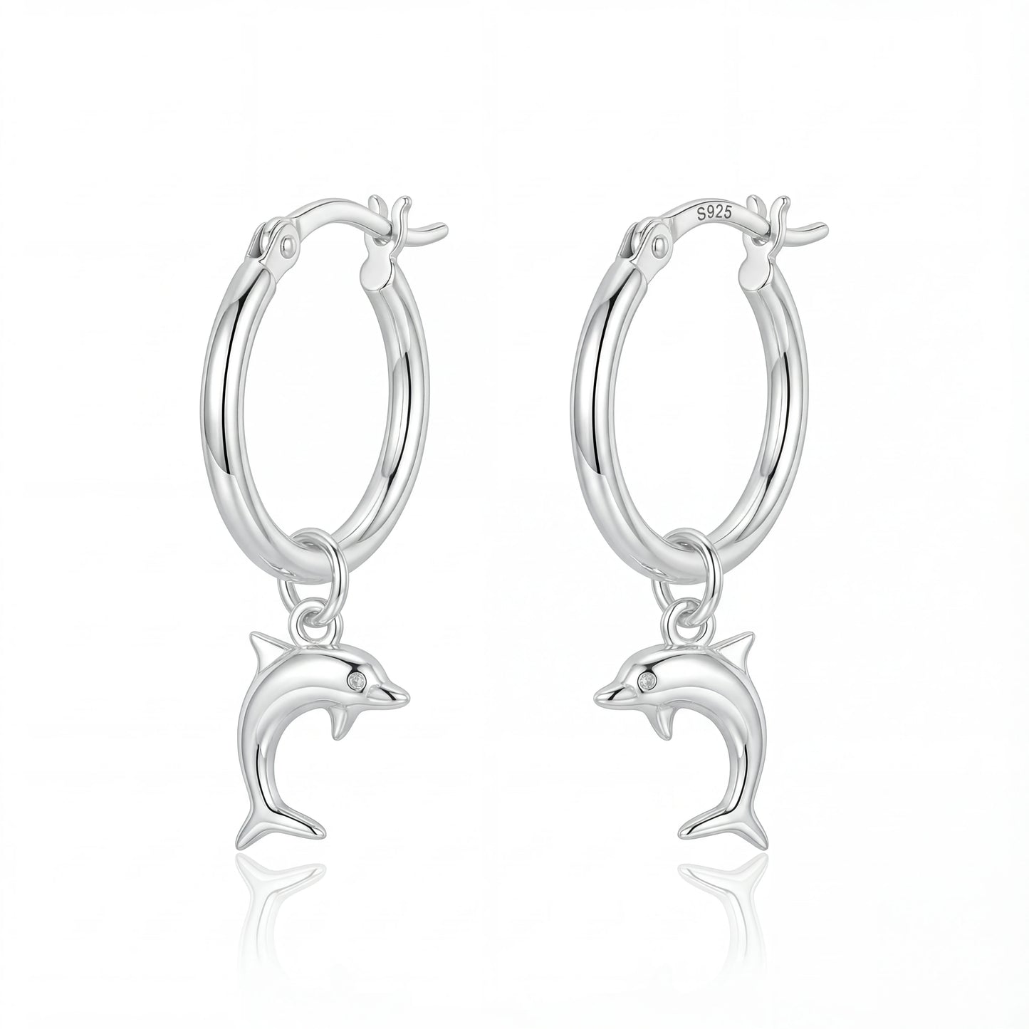 זוג עגילי חישוק מכסף 925 עם תליוני דולפין תלויים, מוארים באור עדין, על רקע כחול ימי. מותג Lidi.