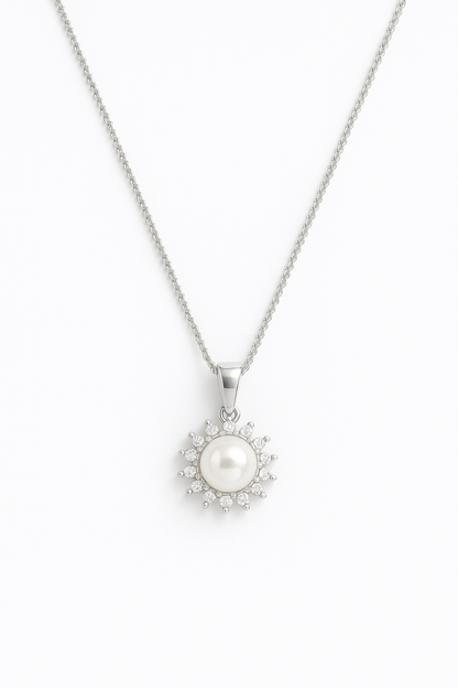 שרשרת ELLA כסופה, תליון עם פנינה לבנה המוקפת אבני זרקון נוצצות בעיצוב דמוי שמש, מבט מלמעלה.