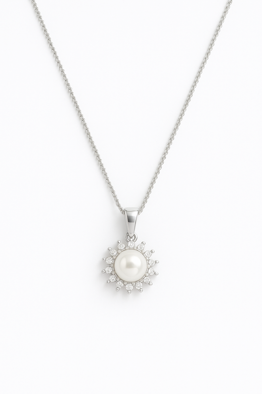 שרשרת ELLA כסופה, תליון עם פנינה לבנה המוקפת אבני זרקון נוצצות בעיצוב דמוי שמש, מבט מלמעלה.