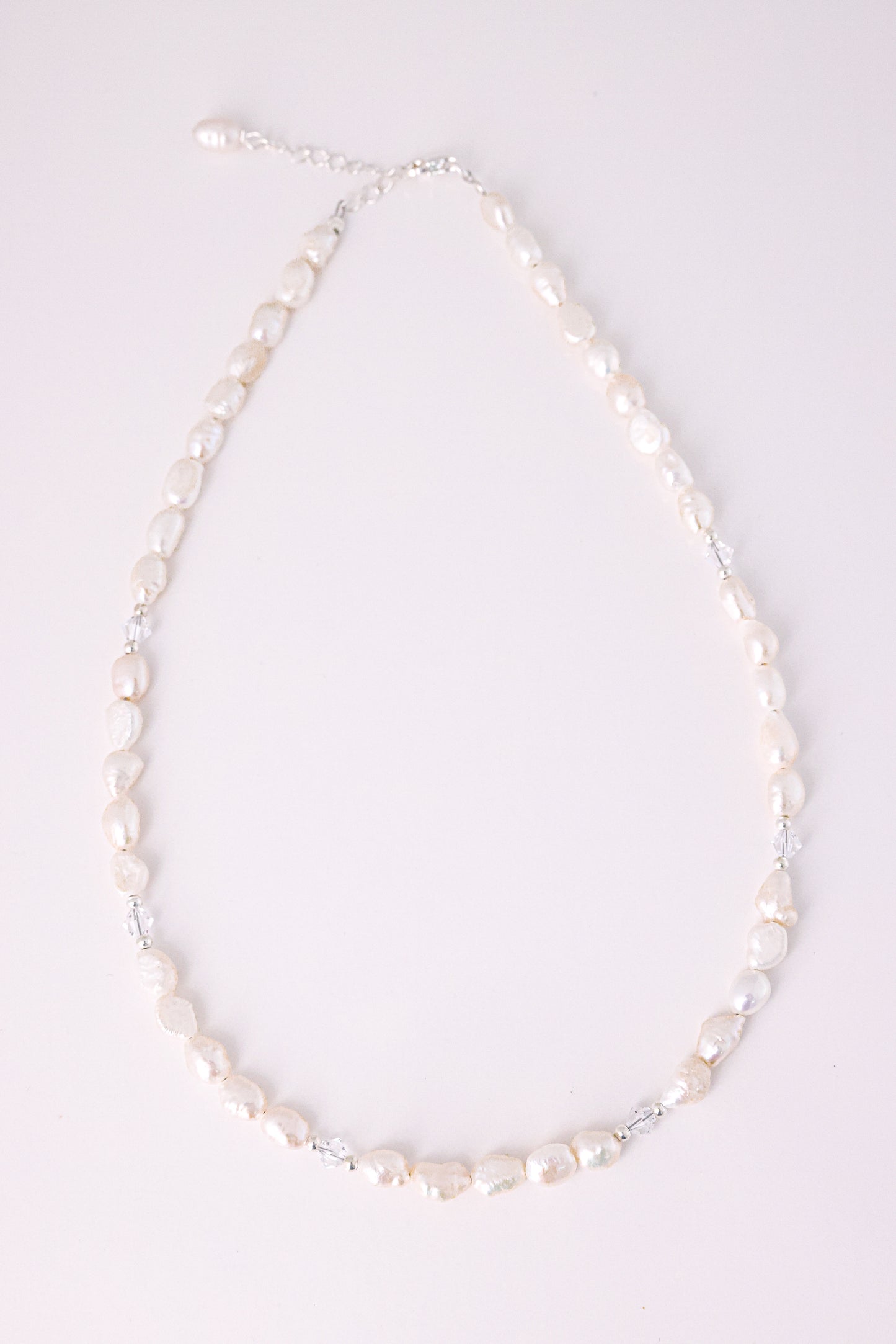 שרשרת ALAMOR QUARTZ SILVER, פניני בארוק לבנות בשילוב קוורץ שקוף, מונחת שטוח על רקע בהיר.