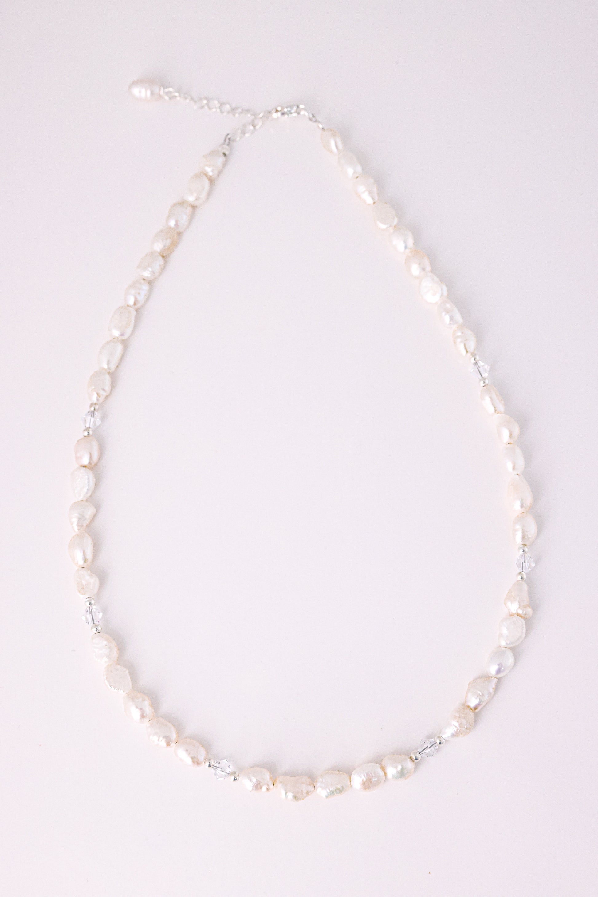 שרשרת ALAMOR QUARTZ SILVER, פניני בארוק לבנות בשילוב קוורץ שקוף, מונחת שטוח על רקע בהיר.