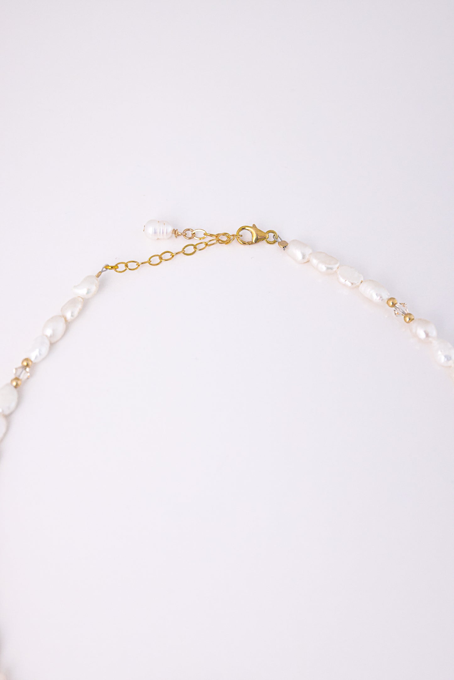 שרשרת ALAMOR BEIGE GOLD, מבט תקריב על סוגר הזהב ושרשרת ההארכה עם פנינים לא סדירות וחרוזי זהב.