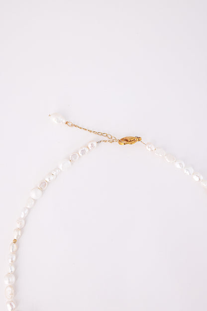 שרשרת SHAI NECKLACE של Lidi. תקריב על סוגר זהב, שרשרת הארכה ופניני בארוק עם חרוז זהב קטן.