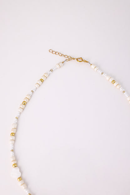 שרשרת LIHI NECKLACE, מבט תקריב מלמעלה על סוגר הזהב וחרוזי הזהב והלבן העדינים.