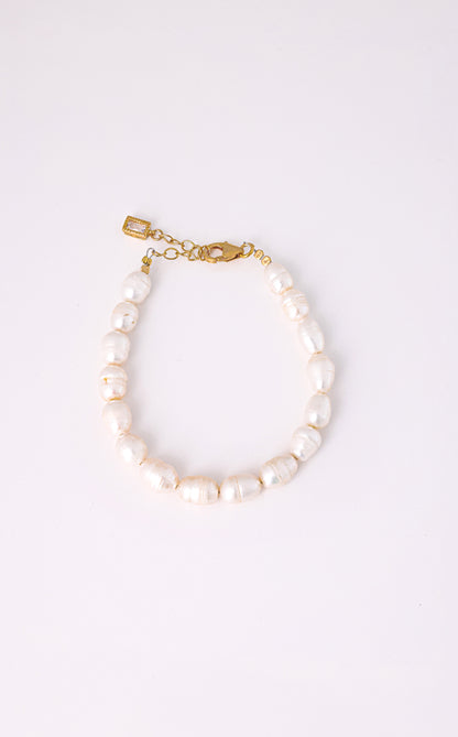 צמיד AMELIA BRACELET פניני בארוק לבנות, סוגר ושרשרת הארכה מזהב עם תליון מלבני, על רקע לבן.