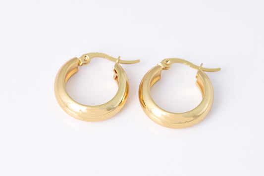 זוג עגילי BLAIR זהב, חישוקים עבים חלקים ומבריקים, צילום מלמעלה על רקע לבן.