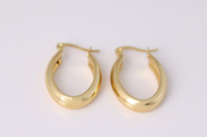 עגילי EDEN זהב, חישוקים אובליים מבריקים, מצולמים מלפנים בתקריב עדין על רקע לבן.