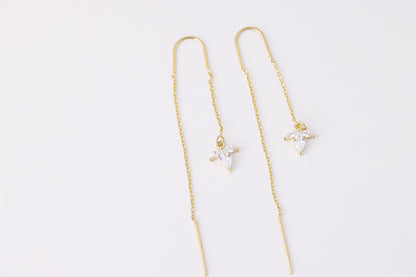 עגילי SARAI מזהב, עיצוב נשפך עם תליון פרח משלוש אבני זירקוניה שקופות. צילום מלמעלה על רקע לבן, מבט מלא.