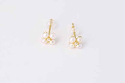 זוג עגילי NOA EARRINGS GOLD צמודים, זהב עם 4 פנינים זעירות ויהלום במרכז, מצולמים מלמעלה על רקע לבן.