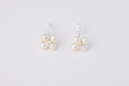 עגילי NOA EARRINGS SILVER כסף, תקריב של זוג עגילים בצורת פרח, עם 4 פנינים עדינות ואבן נוצצת במרכז כל אחד, על רקע לבן.