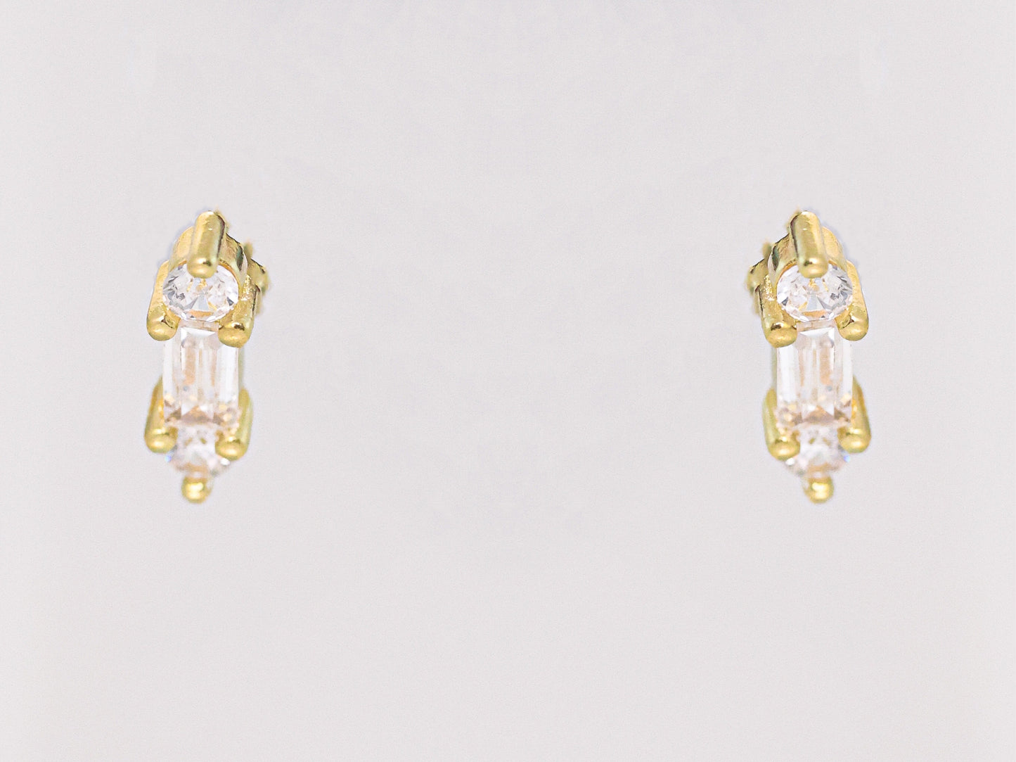 זוג עגילי YUVAL EARRINGS זהב יוקרתיים, משובצים אבני באגט קלאסיות ואבנים עגולות, צילום חזיתי על רקע בהיר.