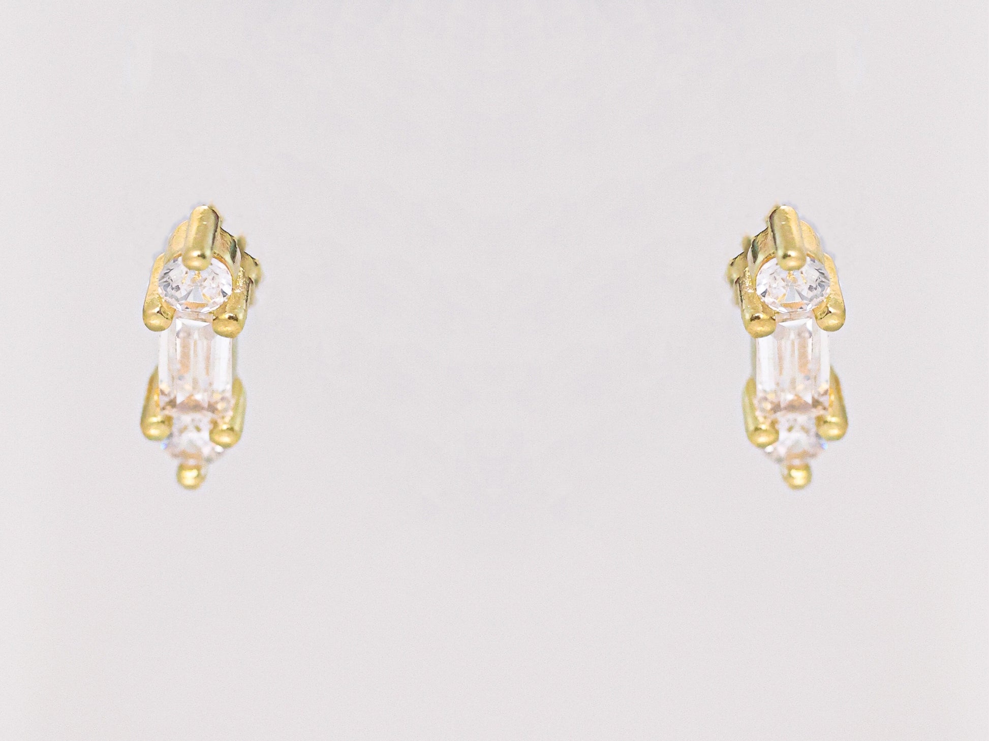 זוג עגילי YUVAL EARRINGS זהב יוקרתיים, משובצים אבני באגט קלאסיות ואבנים עגולות, צילום חזיתי על רקע בהיר.