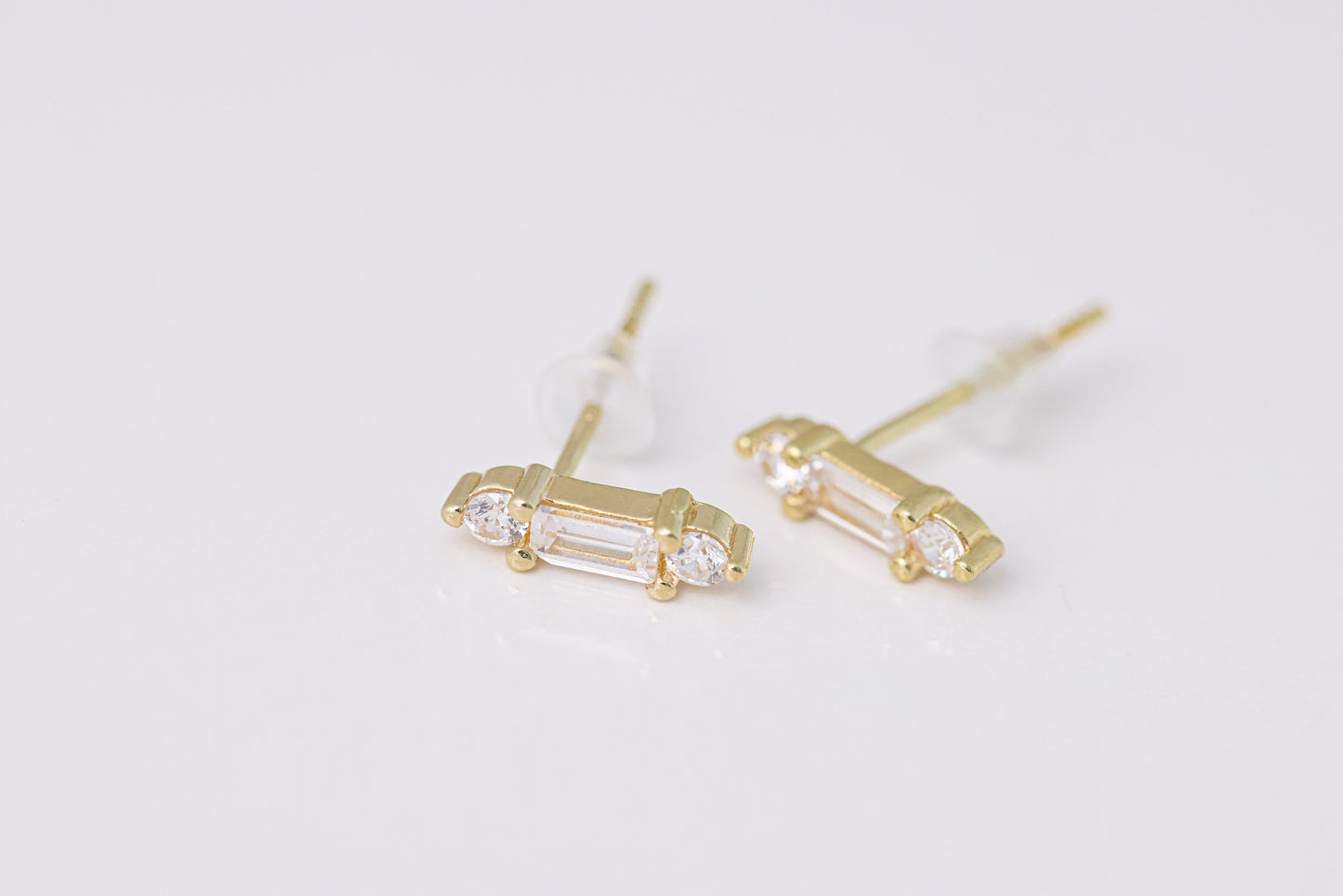 עגילי YUVAL EARRINGS מזהב, משובצים באבני באגט ועגולות, תקריב על העיצוב על רקע לבן.