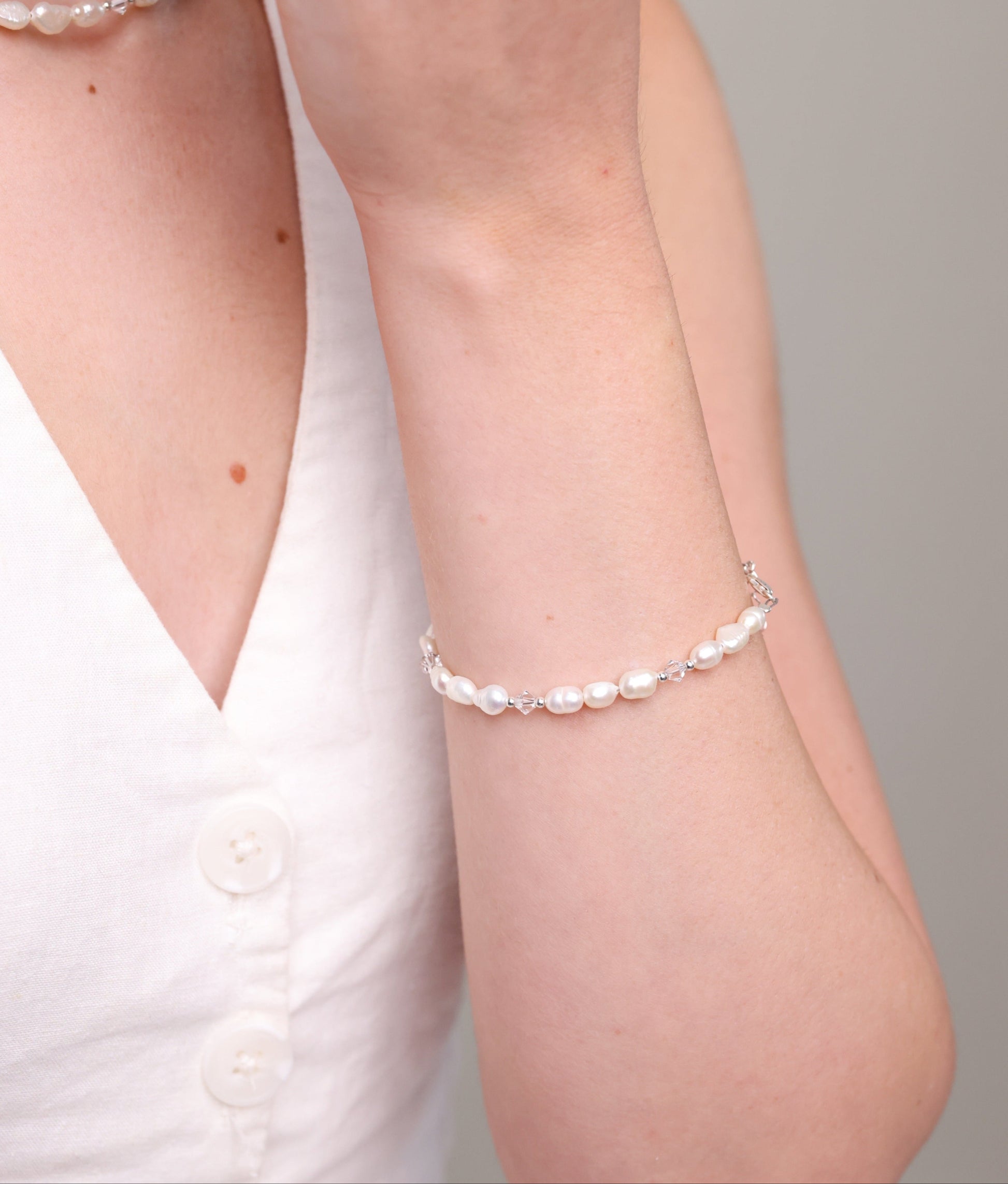 צמיד ALAMOR QUARTZ SILVER פנינים וקוורץ על יד דוגמנית, תקריב על העיצוב המנצנץ.