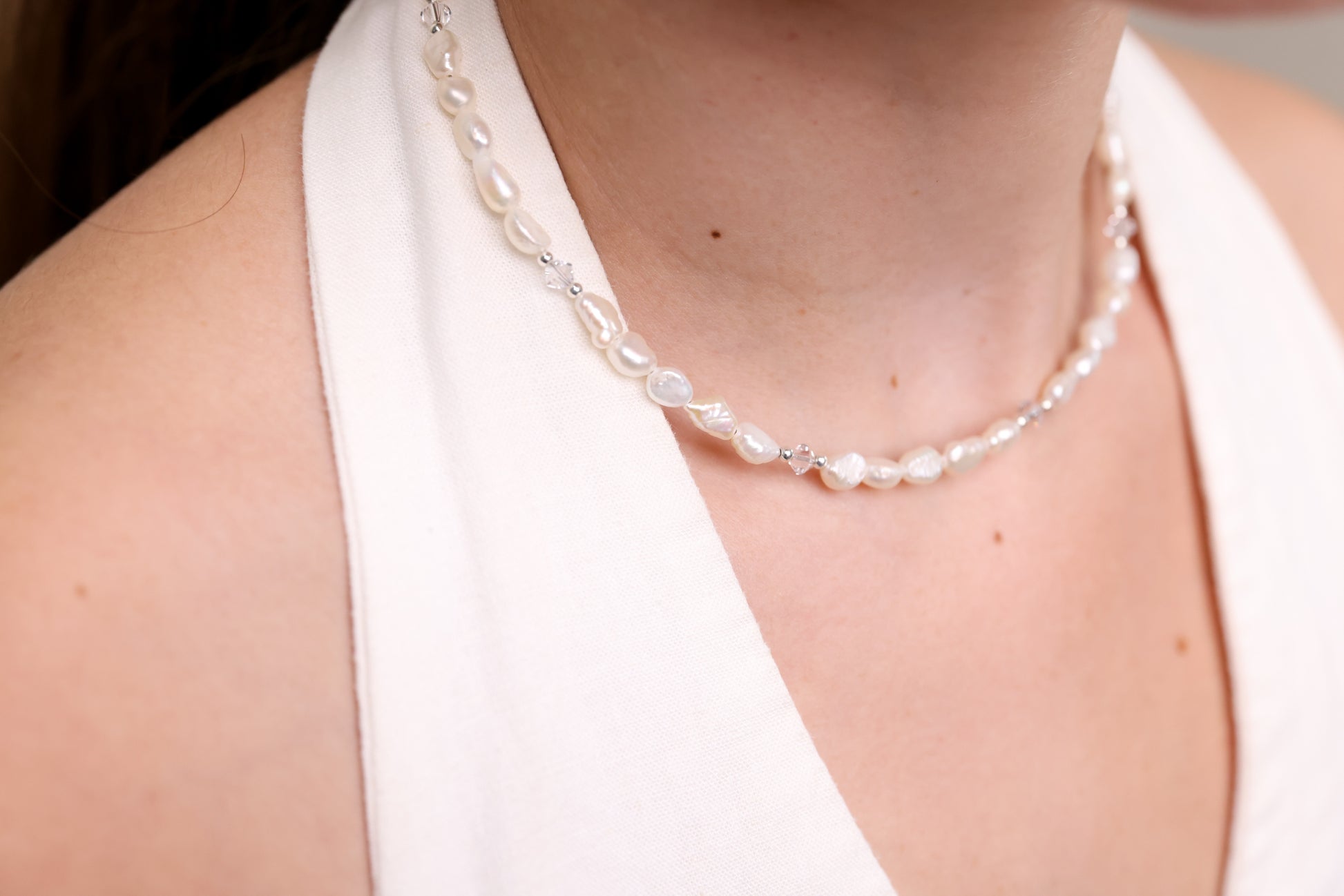 שרשרת ALAMOR QUARTZ SILVER על צוואר דוגמנית, תקריב פנינים בארוקיות משולבות כסף וקריסטלים.