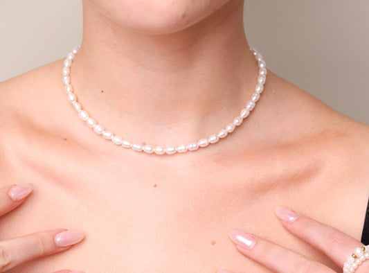 שרשרת פנינים ANNA NECKLACE GOLD על צוואר דוגמנית, מבט תקריב על הפנינים האובליות.