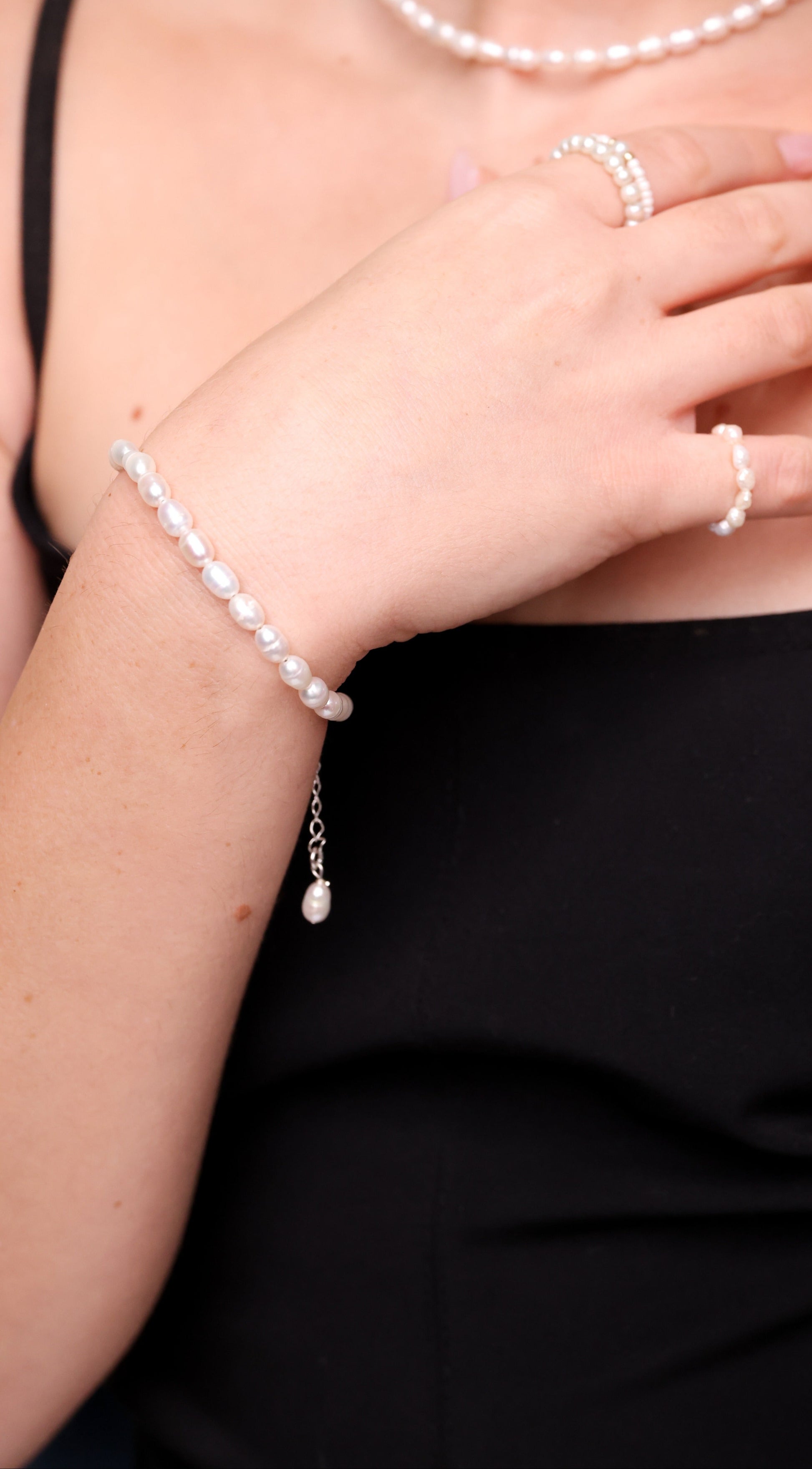 צמיד ANNA BRACELET SILVER עם פנינים טבעיות לא סדירות ותליון פנינה, על פרק יד דוגמנית, תקריב.