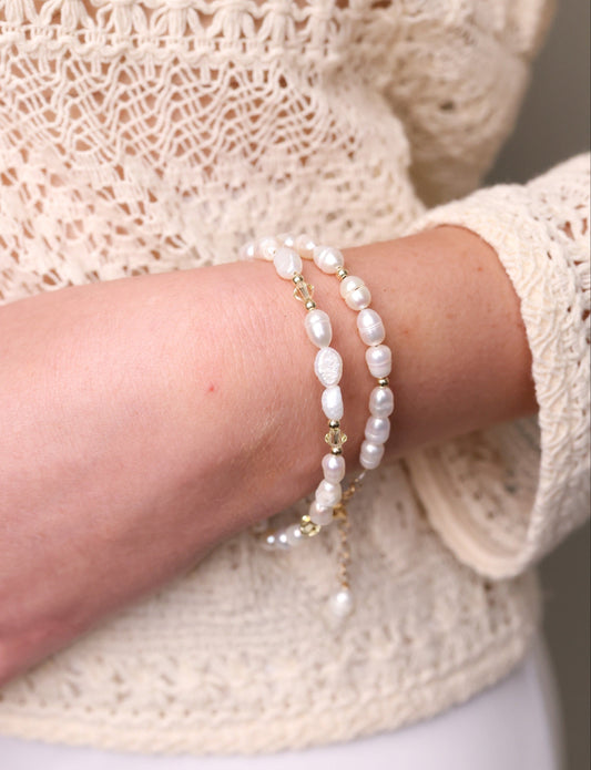 תקריב על צמיד ALAMOR YELLOW GOLD כפול, פנינים אמיתיות וחרוזי זהב, על אמת יד דוגמנית בסריג קרם.