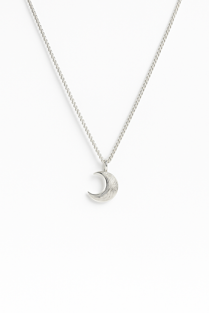 שרשרת MOON כסף, תליון ירח בגימור מוברש עדין, מצולמת מלמעלה על רקע לבן.