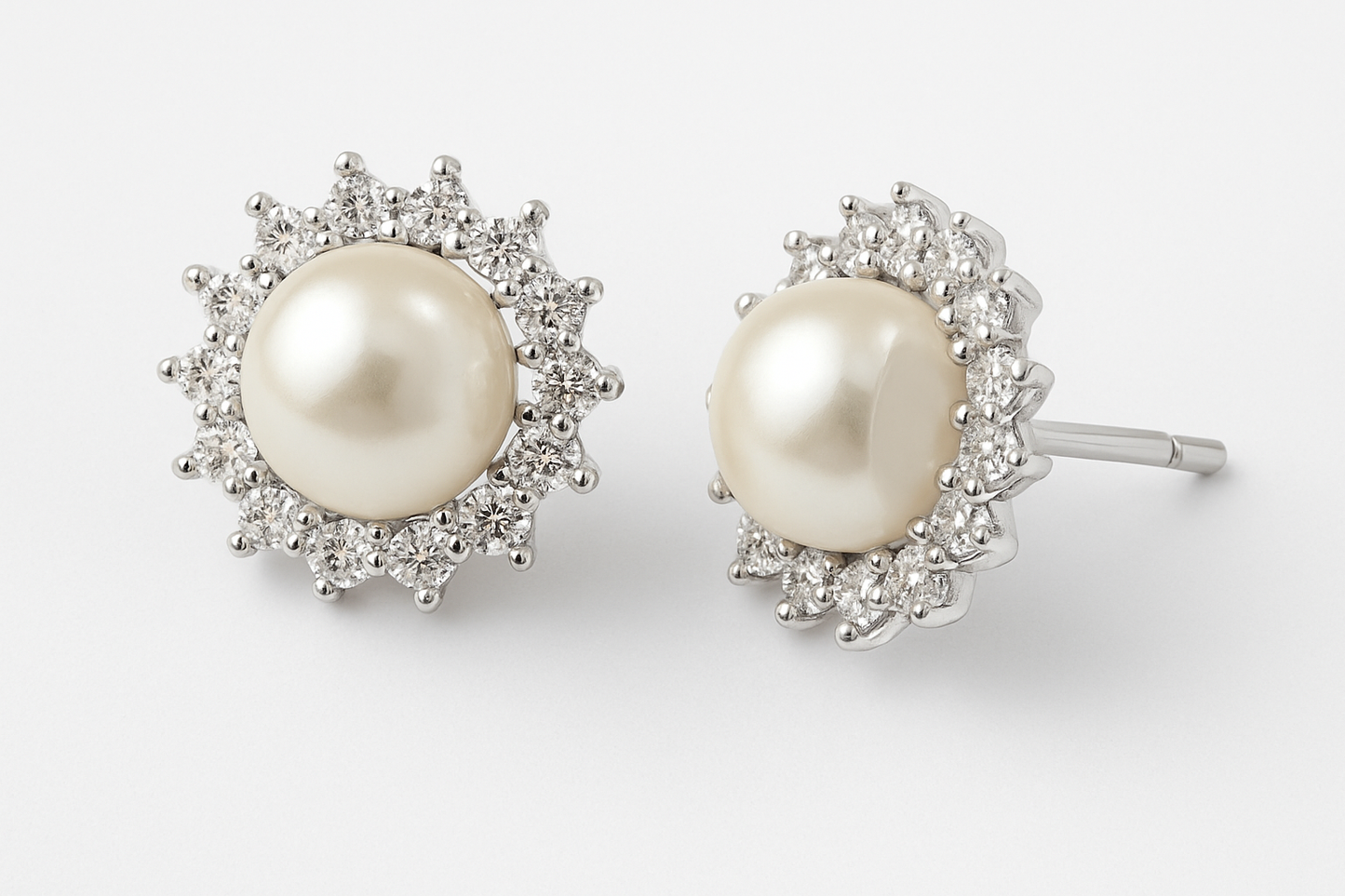 זוג עגילי ELLA מזהב לבן, פנינה במרכז מוקפת הילת יהלומים, אחד מהם חושף את מוט העגיל.