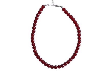 שרשרת ALEN SILVER NECKLACE עם חרוזים אדומים עגולים, מונחת בסגלגל, מבט על סוגר הכסף המבריק.