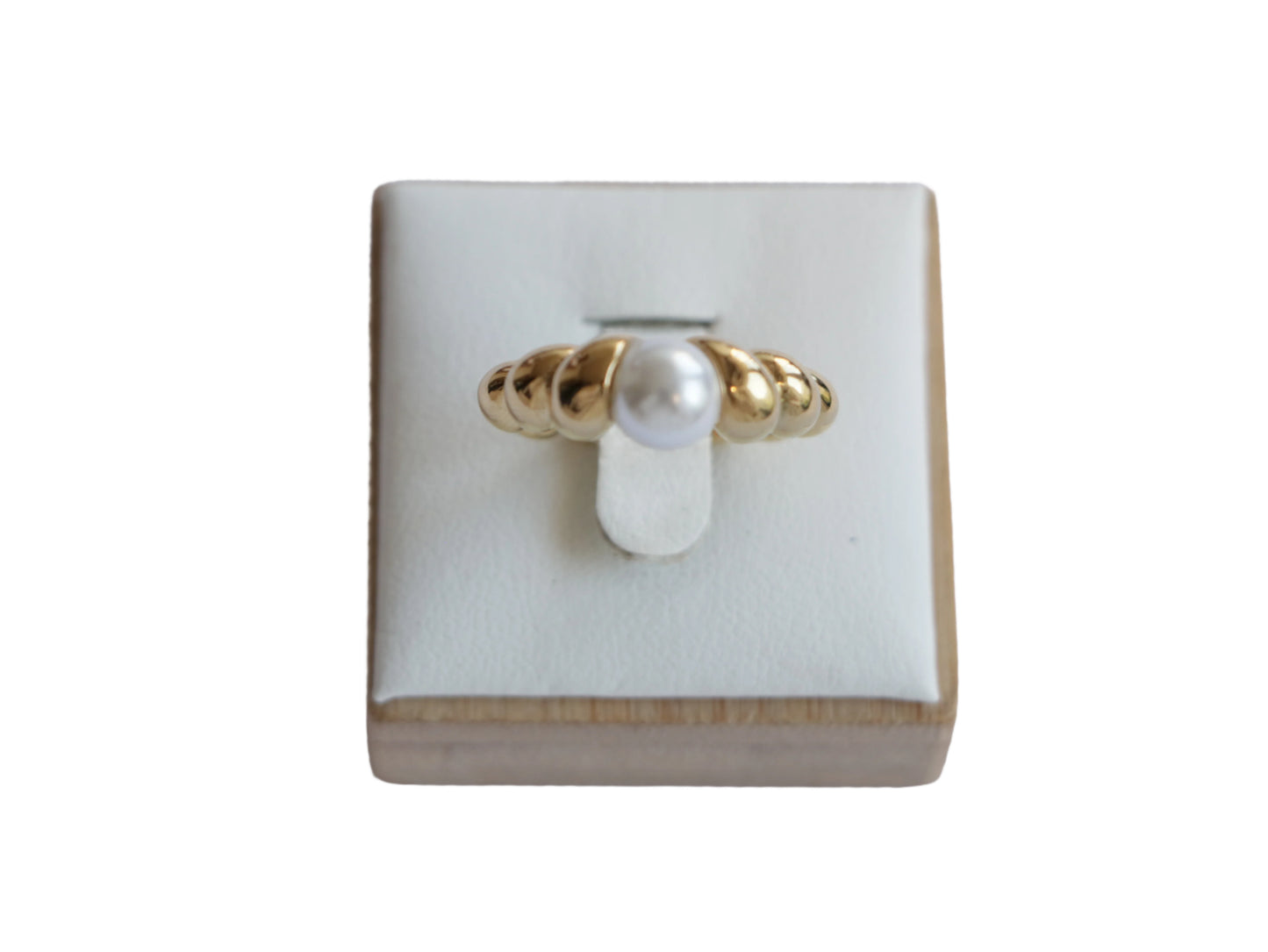 טבעת LOPE מזהב עם פנינה לבנה, בעלת פס גלי ייחודי, מוצגת מקדימה על סטנד.