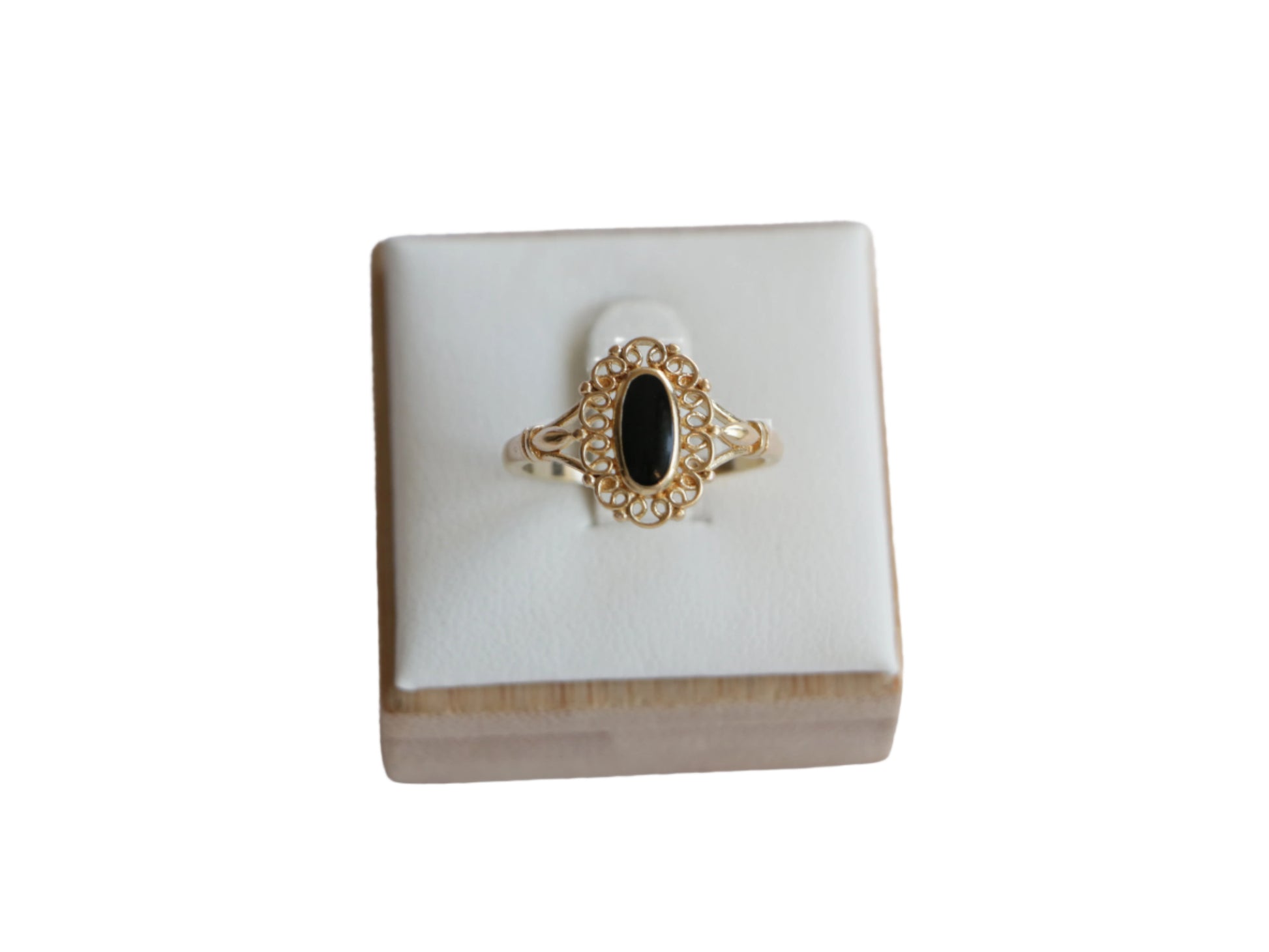 טבעת SOLE זהב עם אבן שחורה אובלית, מעוטרת במסגרת תחרה עדינה, מוצגת על סטנד לבן במבט קדמי.