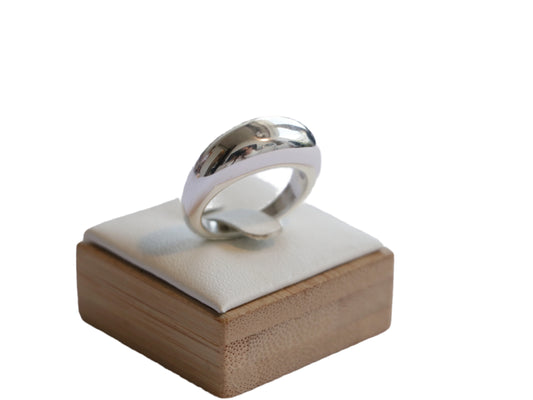 טבעת NIRI RING מכסף סטרלינג בגימור מלוטש וכיפתי, מוצגת במבט קרוב על כרית לבנה על מעמד עץ במבוק.