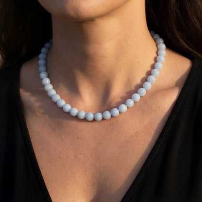 שרשרת ANGEL NECKLACE יוקרתית מכסף 925 עם תליון אבן ג'ייד תכלת עדינה, מונחת על צוואר אישה באלגנטיות, מדגישה את יופיה.