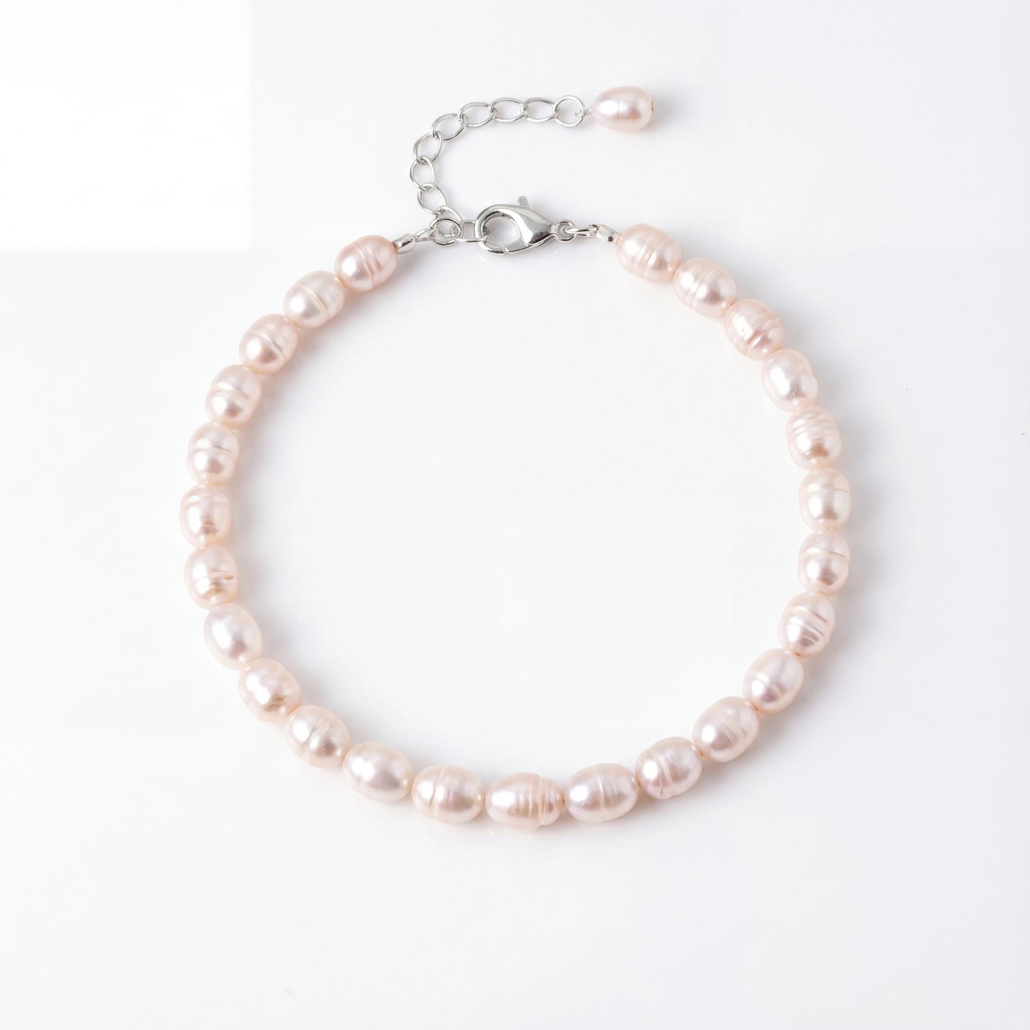 צמיד ANNA SILVER יוקרתי מבית Lidi עם פניני מים מתוקים זוהרות וסוגרי כסף 925 על רקע אלגנטי.