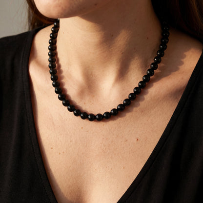 שרשרת צ'וקר ASA NECKLACE עם חרוזים שחורים מבריקים, עשויה מפלדת אל-חלד איכותית, על צוואר דק ואלגנטי.