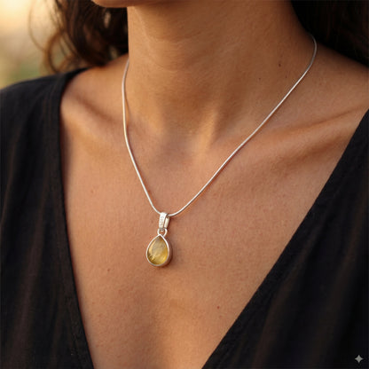 שרשרת NOY יוקרתית של Lidi מכסף 925 טהור עם תליון אבן פרידוט ירוקה וזוהרת על צוואר אישה.