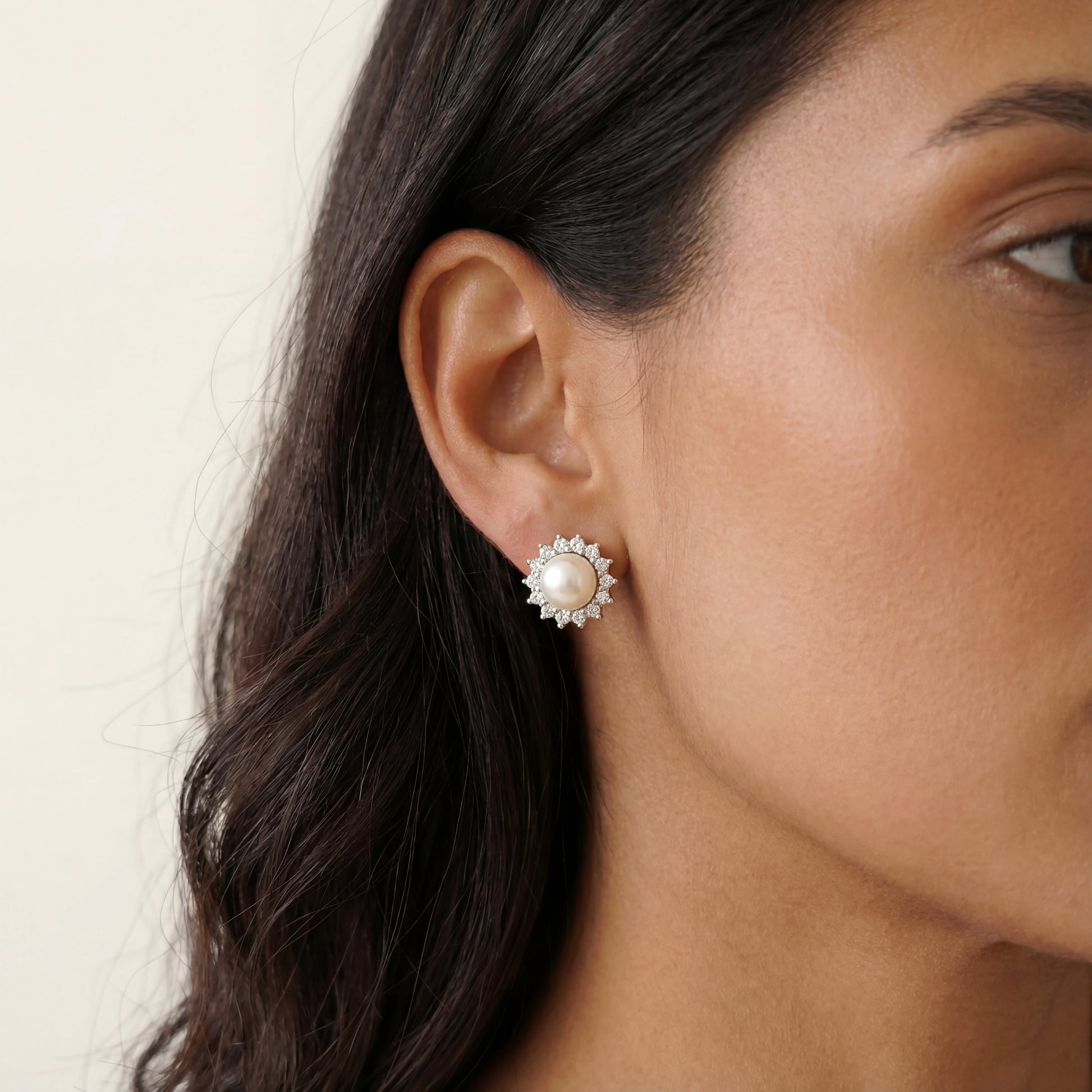 עגילי ELLA EARRINGS צמודים מכסף 925 עם פנינה וזרקונים נוצצים, תלויים בעדינות על אוזן.