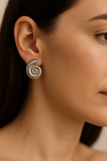 עגיל SHAB SILVER EARRINGS כסף, תקריב על אוזן דוגמנית בפרופיל, מציג את עיצוב הקונכייה הספירלית המפורט.