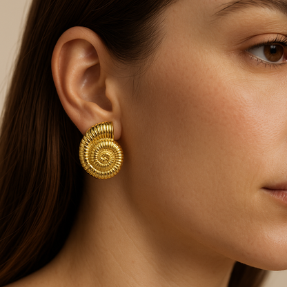 עגיל SHAB GOLD EARRINGS מזהב על אוזן דוגמנית, תקריב של עיצוב הקונכיה המדורג.