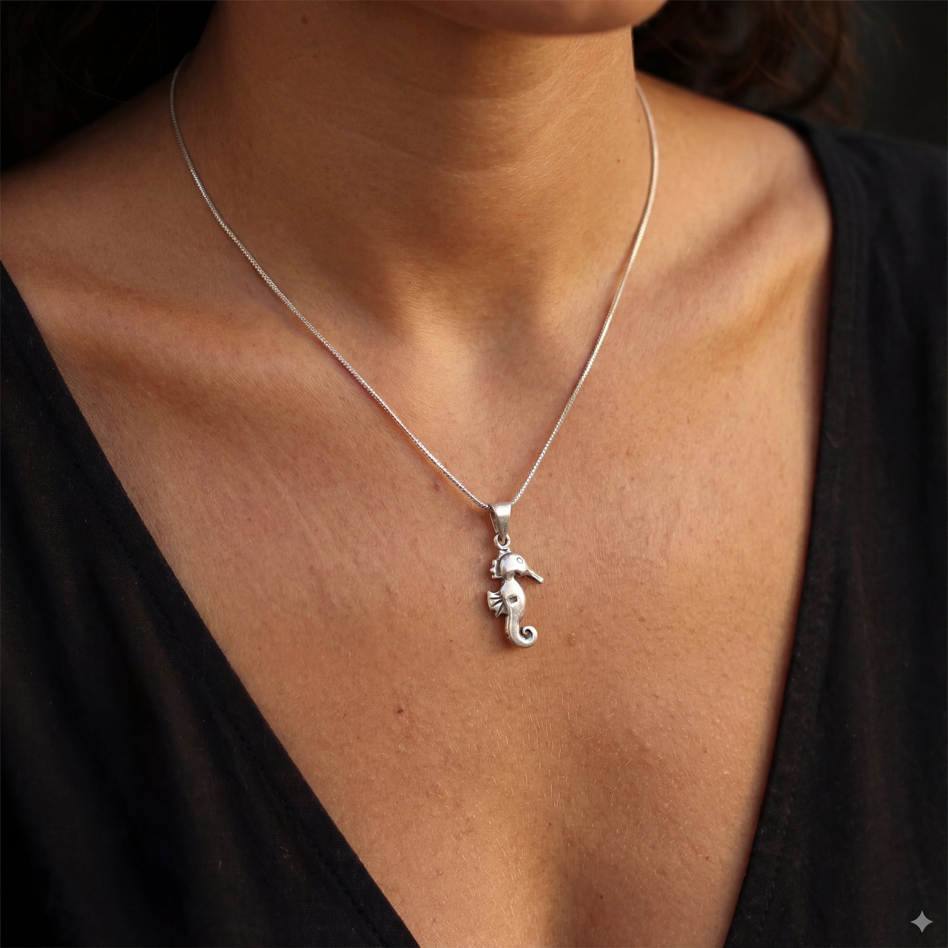 שרשרת YAEL NECKLACE יוקרתית מכסף 925 טהור של Lidi, עם תליון סוסון ים אלגנטי, מונחת על רקע ימי עדין. עמידה במים.