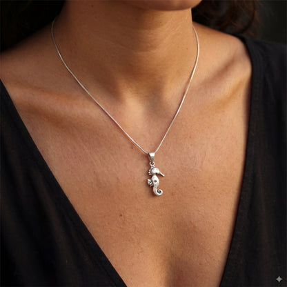 שרשרת YAEL NECKLACE יוקרתית מכסף 925 טהור של Lidi, עם תליון סוסון ים אלגנטי, מונחת על רקע ימי עדין. עמידה במים.